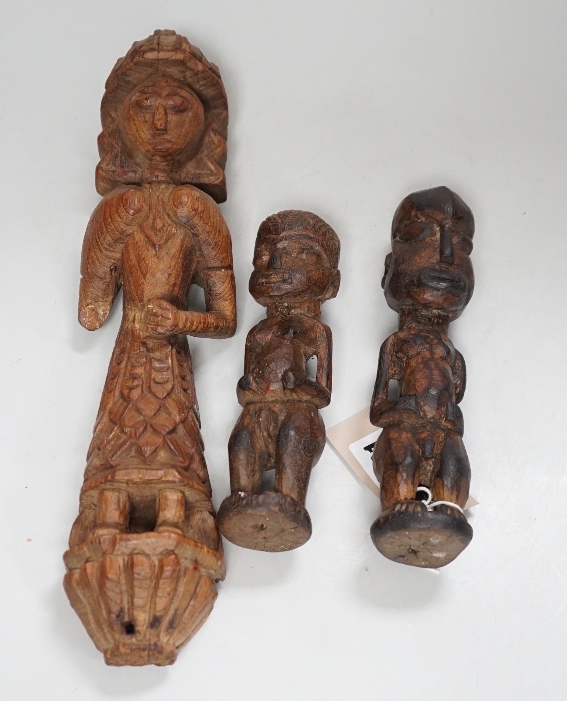 A carved teak terminal figure and two African tribal figures, largest 32cm long